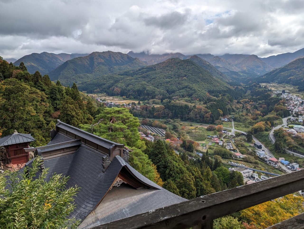 Photo taken from the top of Risshaku-ji temple, Yamadera, Yamagata, Japan. It shows temple buildings in the foreground, and a beautiful valley in the background.